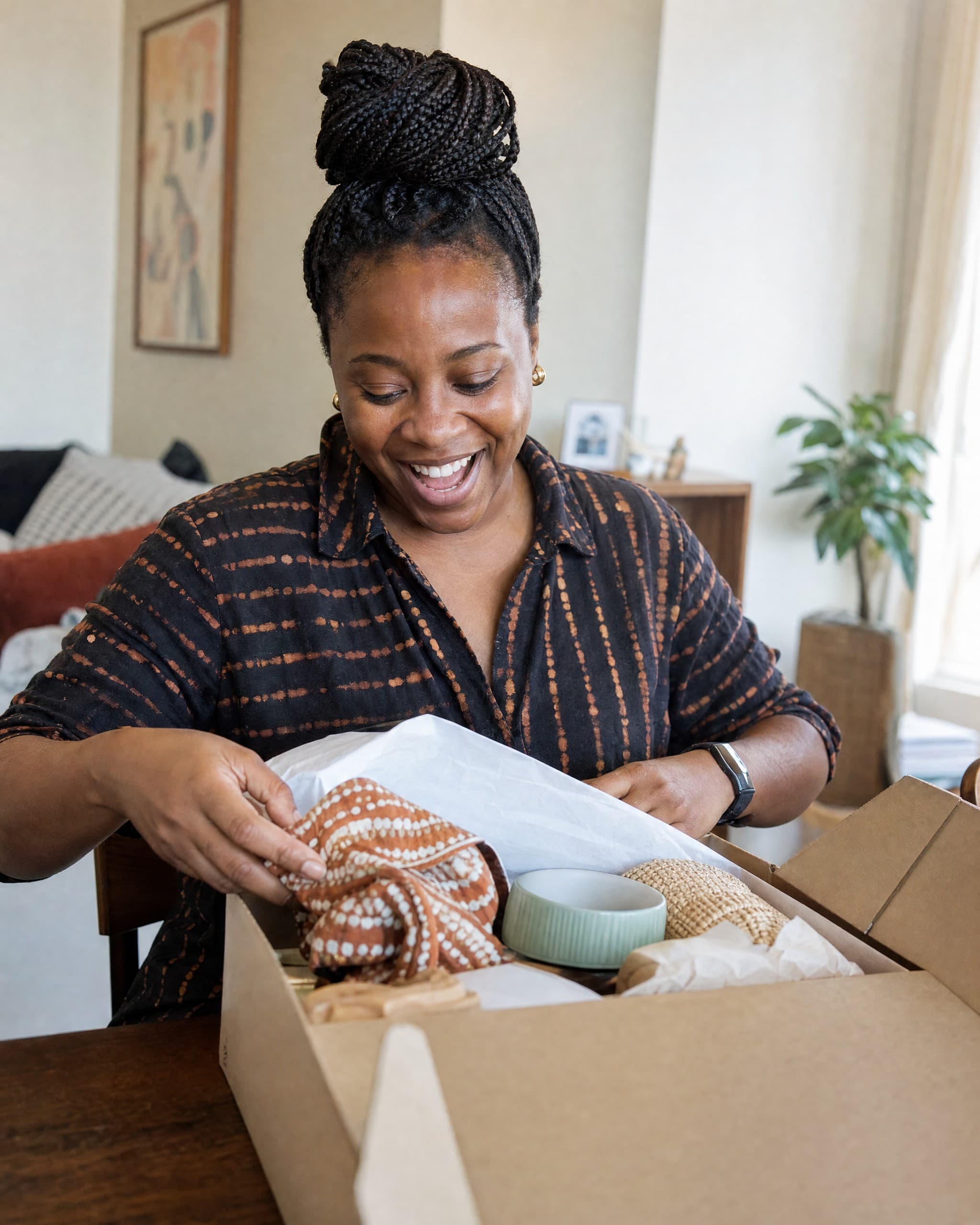 A recipient at home, mid-unbox, smiling with genuine delight as they open a package that has just arrived